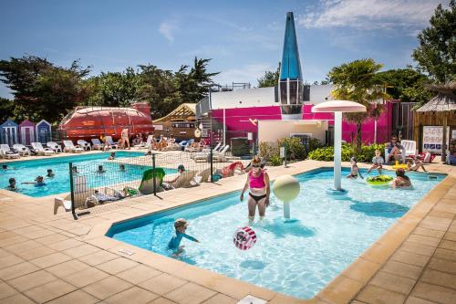 a group of people in a pool at a resort at Camping Insolite Le Haut Village in Saint-Michel-Chef-Chef