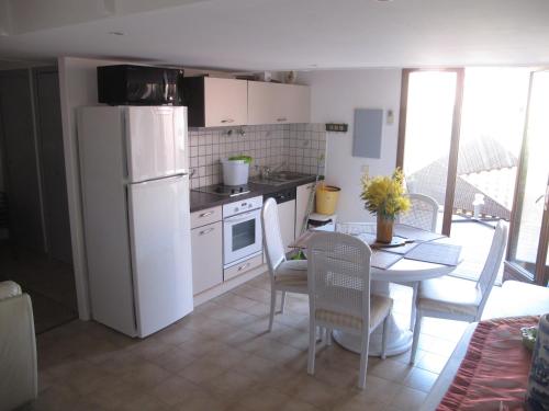 Albitreccia的住宿－MARE BELLU AGOSTA PLAGE，厨房配有白色冰箱和桌椅