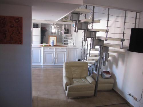a living room with a chair and a spiral staircase at MARE BELLU AGOSTA PLAGE in Albitreccia