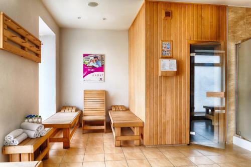 a waiting room with two benches and a table at Focus Hotel Katowice Chorzów in Chorzów