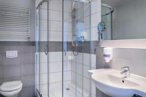 a bathroom with a shower and a sink and a toilet at Focus Hotel Katowice Chorzów in Chorzów