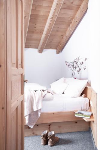 a bedroom with a wooden bed with shoes on the floor at Club Nordic in Sankt Anton am Arlberg