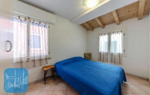 1 dormitorio con 1 cama azul y 2 ventanas en Casamarin8, en Caorle