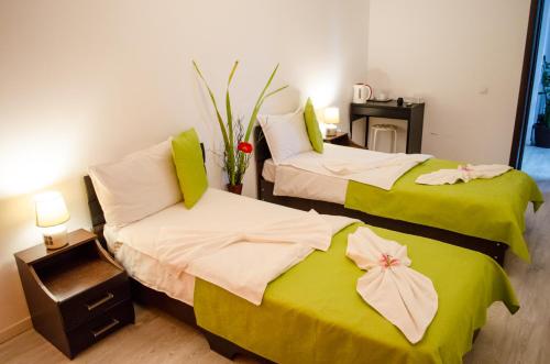 two beds in a room with green and white sheets at City Lux Villa in Bucharest