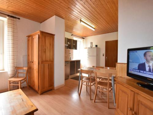 a kitchen and dining room with a table and a television at Apartment in La Bresse with Ski Storage Garden Terrace BBQ in La Bresse