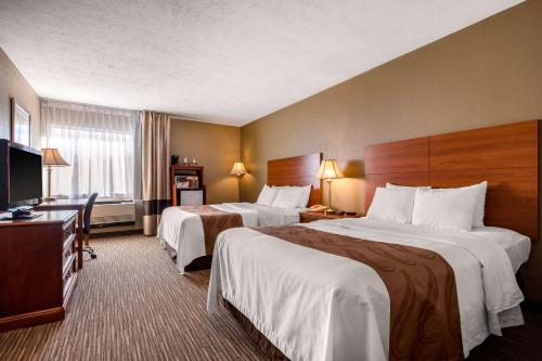um quarto de hotel com duas camas e uma televisão de ecrã plano em Quality Inn & Suites New Castle em New Castle