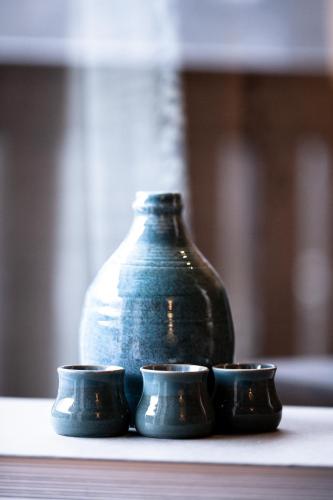 a vase and three cups sitting on a table at Club Nordic in Sankt Anton am Arlberg