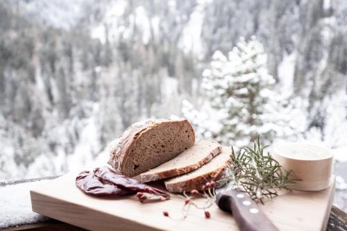 a loaf of bread on a cutting board with a knife at Club Nordic in Sankt Anton am Arlberg
