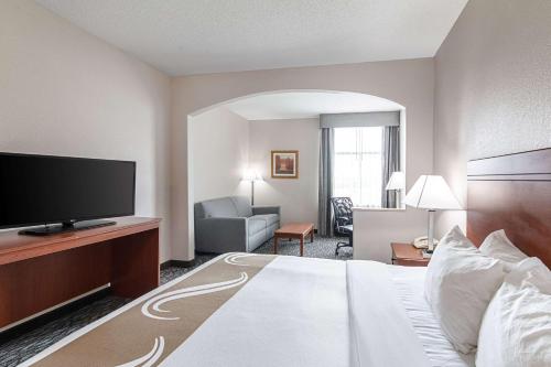 a hotel room with a large bed and a television at Quality Suites in Austin