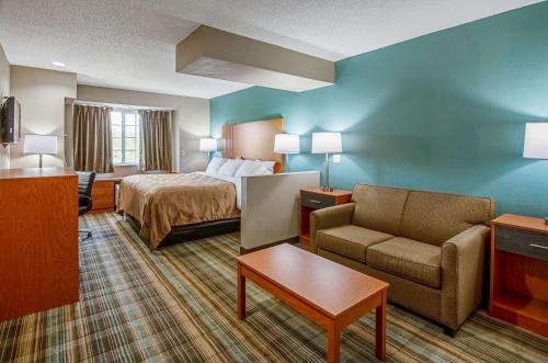 a hotel room with a bed and a couch and a chair at Quality Inn & Suites I-81 Exit 7 in Bristol
