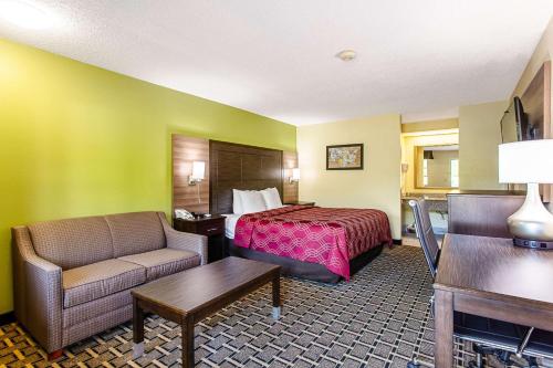 une chambre d'hôtel avec un lit et un canapé dans l'établissement Econo Lodge Russellville, à Russellville
