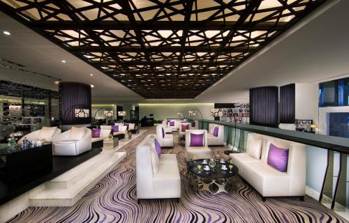 a lobby with white couches and purple pillows at Sofitel Abu Dhabi Corniche in Abu Dhabi