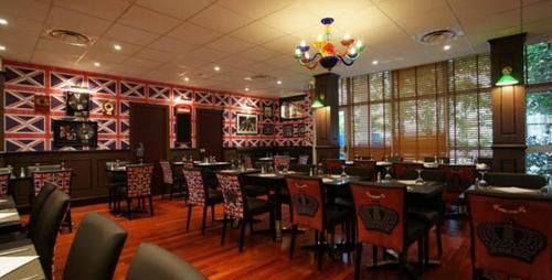 a restaurant with tables and chairs in a room at Greenhotels Roissy Parc des Expositions in Tremblay En France