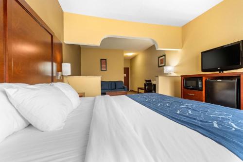 a hotel room with a bed and a flat screen tv at Comfort Suites in Findlay
