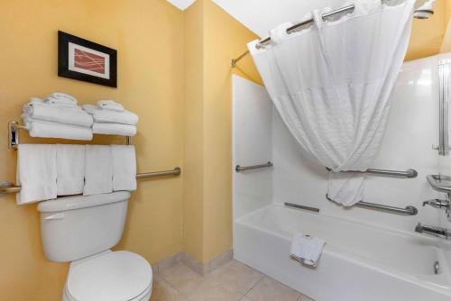 a bathroom with a toilet and a shower with towels at Comfort Suites in Findlay