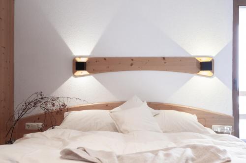 a bedroom with a white bed with a light above it at Club Nordic in Sankt Anton am Arlberg