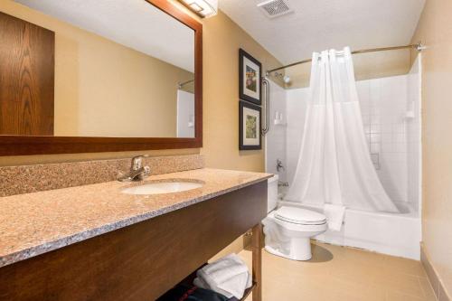 a bathroom with a sink and a toilet and a mirror at Comfort Inn Lathrop Stockton Airport in Lathrop