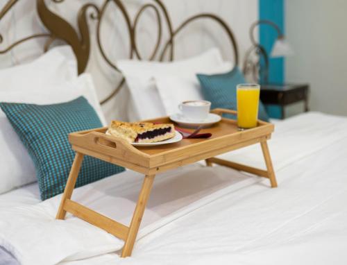 una bandeja con un trozo de tarta sobre una mesa en una cama en Hotel DUM en Belgrado