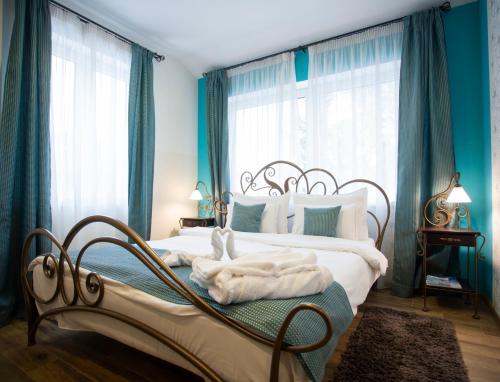 1 dormitorio con 2 camas, paredes y ventanas azules en Hotel DUM en Belgrado
