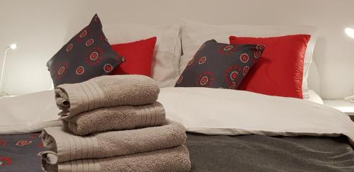 a pile of towels sitting on a bed with pillows at Apartments Vijolica in Kranjska Gora
