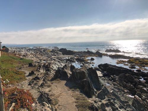 a rocky shore with the ocean in the background at Delfín Apart in Pichilemu