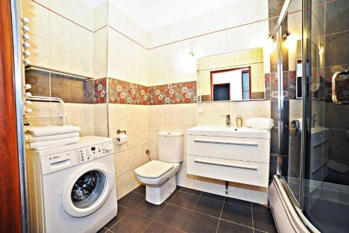 a bathroom with a toilet and a washing machine at Grand Apartments - Neptun Park Maritime Apartment with balcony in Gdańsk
