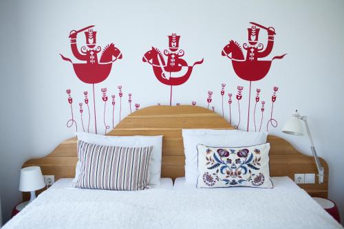a bedroom with a bed with red anchors on the wall at Hotel Bonvino Badacsony in Badacsonytomaj