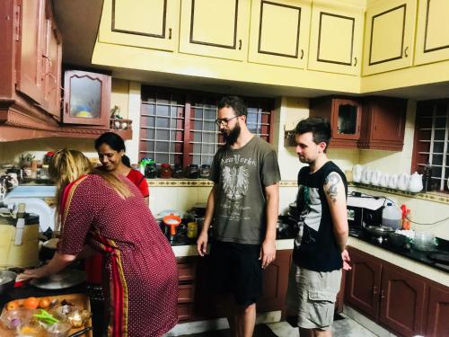 a group of people standing in a kitchen at Bastian Homestay in Cochin