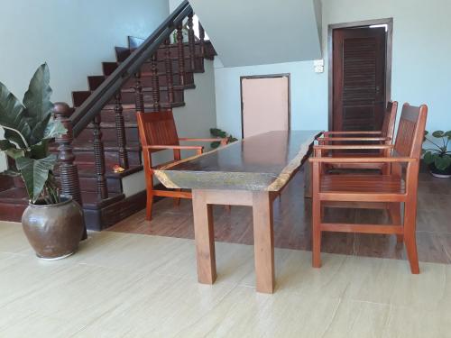 a dining table and chairs in a room at Mama Leurth Sunset Guesthouse in Don Det
