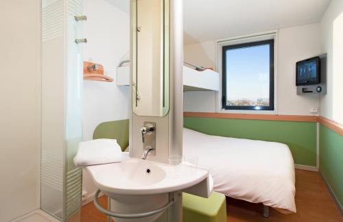 uma casa de banho com um lavatório e um beliche. em ibis budget Toulouse Aeroport em Blagnac
