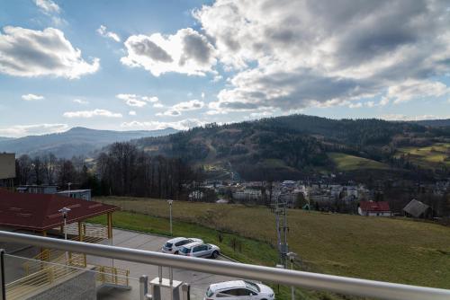 a view of a mountain with cars parked in a parking lot at Apartament Na Urlop - Wisła Kamienna - Apartamenty z widokiem na panoramę Wisły in Wisła