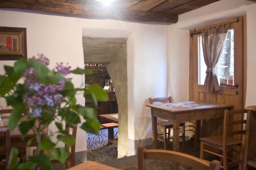 a dining room with a table and chairs and a window at Contrada Beltramelli in Villa di Tirano