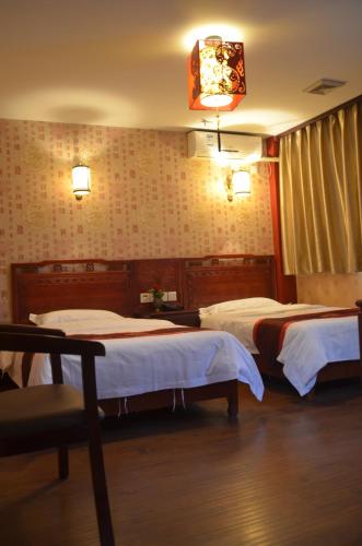 a hotel room with two beds and a lamp at Qianmen Courtyard Hotel in Beijing