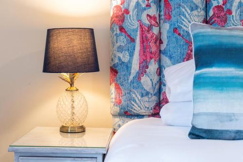 a bedroom with a bed with a lamp on a night stand at Y Branwen Restaurant & Rooms - Adult Only and Dog Friendly in Harlech