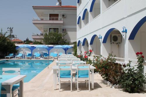 a row of tables and chairs next to a swimming pool at Altinyaz Hotel in Çeşme