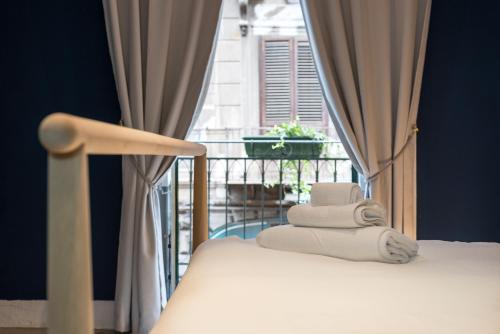 un letto in una stanza con finestra e asciugamani di Qasr Home Beautiful apartment in Palermo a Palermo