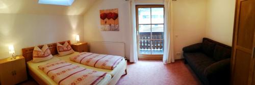 a bedroom with two beds and a couch and a window at Appartement Valentin in Ehrwald