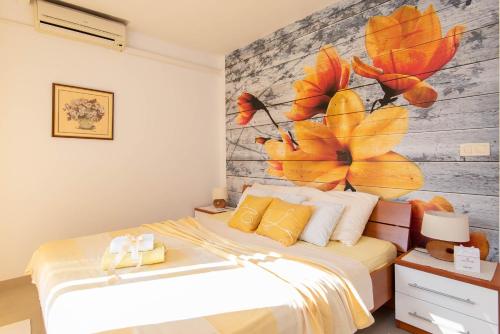 a bedroom with a bed with a flower mural on the wall at Apartments Lenka in Orebić