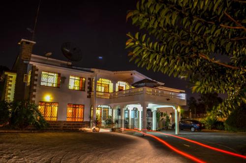 a large white house at night with its lights on at Bonsai Villa in Nairobi