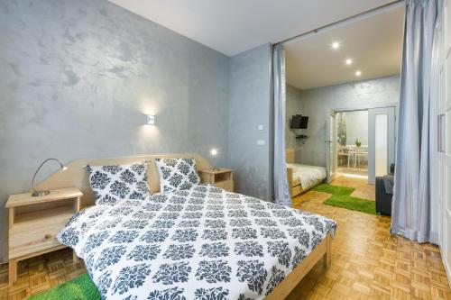 Schlafzimmer mit einem Bett mit einer schwarzen und weißen Bettdecke in der Unterkunft Mikolajska Residence in Krakau