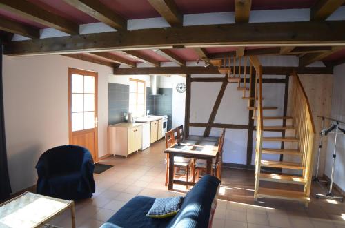 - un salon avec une table et un escalier en colimaçon dans l'établissement Gîte Cigogne, à Odratzheim