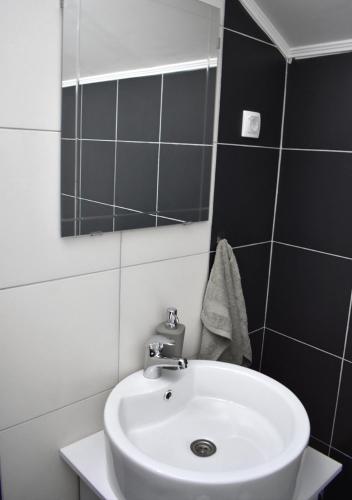 a bathroom with a white sink and a mirror at Apartmani Zrenjanin in Zrenjanin