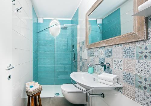 a bathroom with a sink and a toilet and a mirror at Lulù Capri in Anacapri