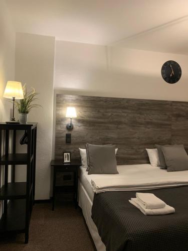 a hotel room with a bed and a clock on the wall at Hamburg Apart in Hamburg