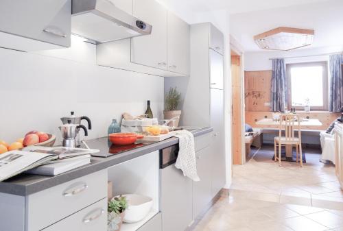 uma cozinha com armários brancos e uma bancada em Apart Korona em Sankt Anton am Arlberg