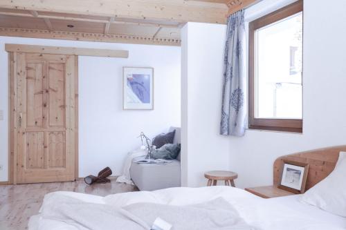 a white bedroom with a bed and a window at Club Nordic in Sankt Anton am Arlberg