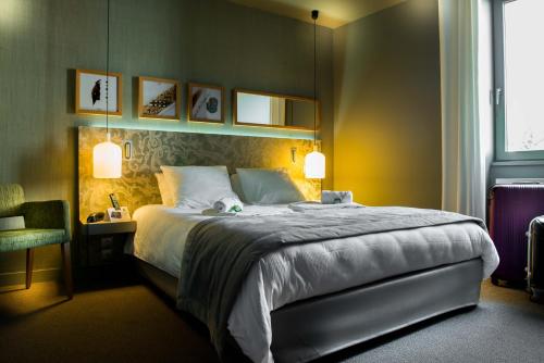 a hotel room with a large bed and a desk at Logis Hôtel Tante Yvonne & son restaurant semi-gastronomique - Lyon Nord in Quincieux