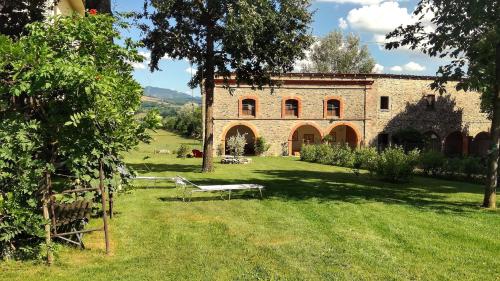 a park bench in front of a brick building at Agriturismo Casa Agricola Rossi Appartamenti in Casentino in Soci