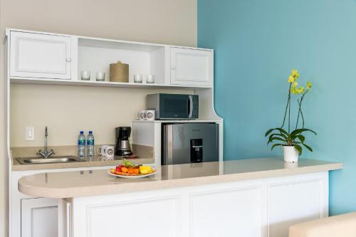 a kitchen with white cabinets and a plate of fruit at Margaritaville Beach Resort Playa Flamingo in Playa Flamingo
