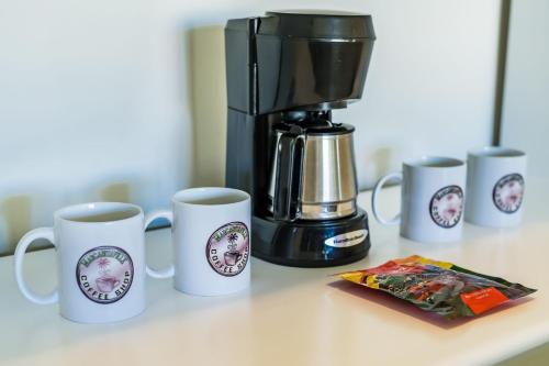 a coffee maker and coffee cups on a counter at Margaritaville Beach Resort Playa Flamingo in Playa Flamingo